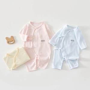 Detail view of cotton rib-knit fabric and tie-front closure on long sleeve baby bodysuits