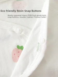 Détail de barboteuse pour bébé avec pressions en résine POM et imprimé fraise rose