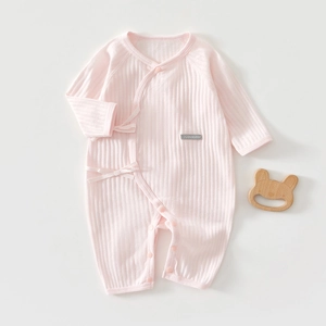 Detail of light pink baby cotton bodysuit with ribbed texture and front tie closure