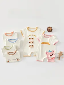 Detail of baby cotton romper featuring adorable cartoon prints and contrast piping edges