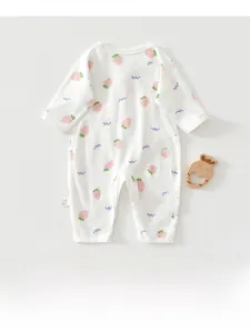 Détail d'une barboteuse bébé à motif fraise avec étiquette latérale et coton doux