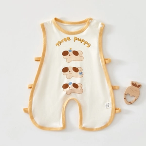 Close-up of baby romper featuring orange piping, three puppy print and side-tie details