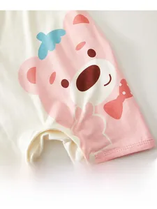 Detailed macro view of baby cotton bodysuit featuring pink bear print and bow decoration