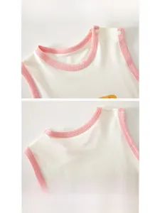Detail of baby sleeveless romper showing snap buttons on shoulder and soft pink edging