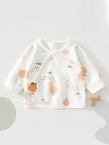 Close-up of newborn cotton wrap shirt featuring a delicate peach print and side-tie design