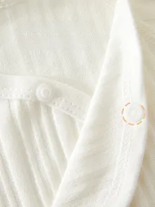 Detail of high-quality white cotton ribbed baby bodysuit with eco-friendly resin snaps