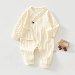 Detail of baby organic cotton romper with vertical ribbed texture and crown logo