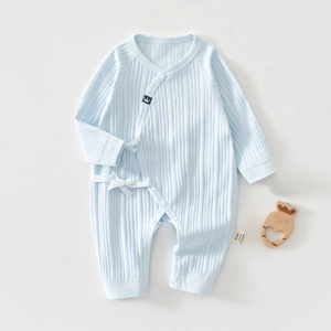 Close-up of light blue ribbed cotton baby romper with ribbon ties and crown logo