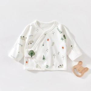 Close-up of baby cotton kimono shirt with green forest print and embroidery detail