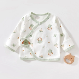 Close-up of baby cotton kimono shirt featuring cute space dog prints and soft green piping