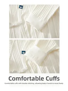Detail of ribbed cotton cuffs with double-stitching and blue crown on baby romper