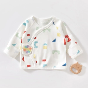 Detail of newborn organic cotton wrap top featuring colorful geometric prints and sunflower patch