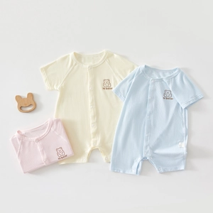 Detailed view of ribbed cotton baby bodysuits with snap buttons and hi bear embroidery