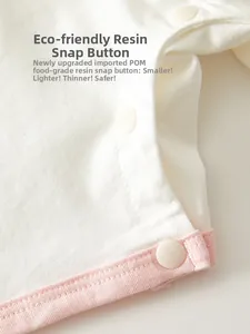 Detail of baby cotton romper featuring pink trim and food-grade POM resin snap fasteners