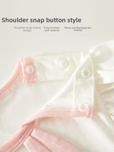 Macro shot of shoulder snap buttons on a soft cotton baby bodysuit with pink trim