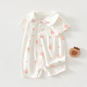 Détail d'un barboteuse bébé avec motifs de pêches et lapins, col à nœuds et boutons
