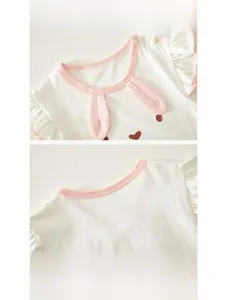 Detail of baby cotton romper featuring rabbit ears, ruffle sleeves and snap buttons