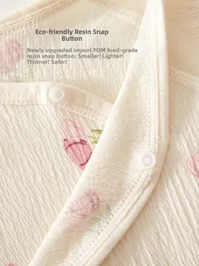 Detail of newborn baby crepe cotton romper with pink tulip prints and resin snap buttons