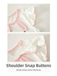 Detailed view of resin shoulder snaps on baby white bodysuit with pink trim and ruffles