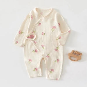 Detail of newborn floral baby romper showing soft seersucker fabric and snap closures