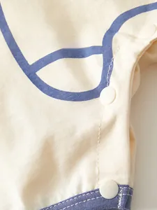 Detail shot of the baby bodysuit featuring neat stitching and white resin snap buttons