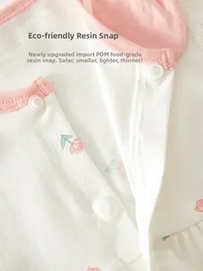 Gros plan des boutons-pression en résine POM sur barboteuse bébé à fleurs