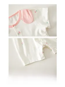 Détail du barboteuse bébé à imprimé roses roses avec bords en coton doux et boutons-pression
