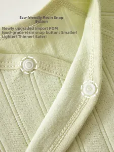 Macro view of food-grade resin snap buttons on newborn ribbed cotton apparel