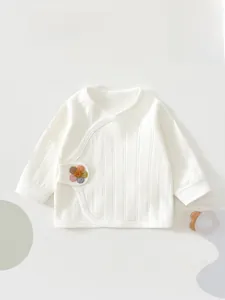 Macro detail of white cotton newborn kimono wrap with rainbow flower and rib knit texture