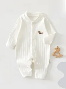 Détail d'une barboteuse en coton pour bébé avec texture côtelée et broderie chiot