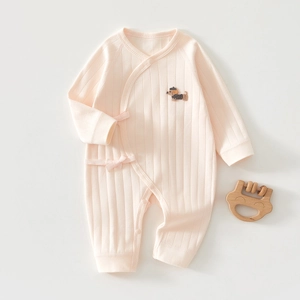 Detail of peach pink cotton newborn romper with dog embroidery and ribbon tie
