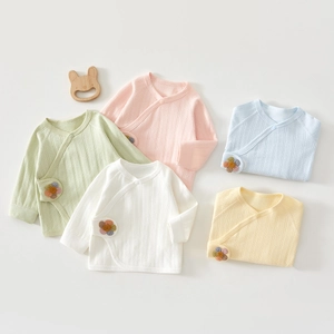 Close-up of five colorful newborn baby kimonos in soft ribbed cotton with flower embroidery