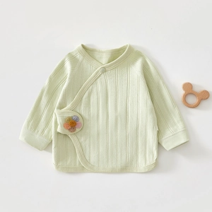 Detail of soft organic cotton baby wrap top with delicate floral applique and snap button