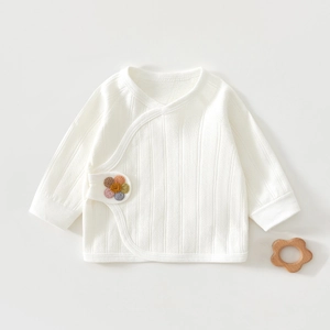 Detail of newborn cotton baby kimono top with ribbed texture and floral embroidery