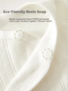 Close-up of food-grade POM resin snap fasteners on white ribbed cotton newborn baby shirt