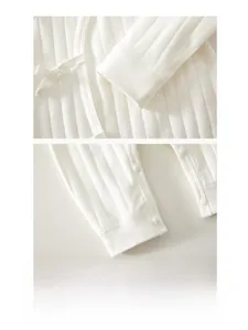 Detail of baby romper featuring side-tie bow cuffs and durable snap buttons on cotton fabric