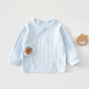 Macro shot of light blue newborn cotton kimono top with cute woven flower detail