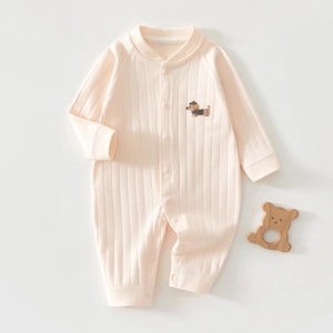 Détail d'un barboteuse rose en coton pour bébé avec broderie chiot et tissu côtelé doux