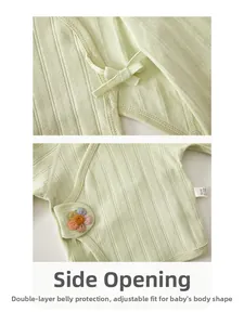 Detail of newborn green ribbed cotton shirt with side-tie closure and floral embroidery