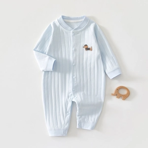 Détail macro du pyjama bébé en coton côtelé avec une broderie de chiot délicate