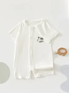 Detail eines weißen Kurzarm-Baby-Stramplers mit Hundeprint und Druckknopfverschluss