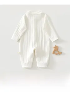 Détail de la grenouillère bébé blanche à manches longues avec texture côtelée en coton pur