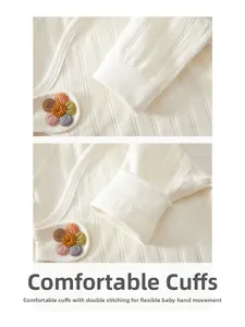Detailed close-up of newborn organic cotton ribbed cuffs with colorful embroidered flowers