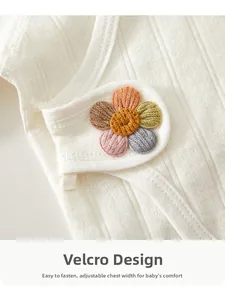 Close-up of newborn cotton top featuring magic tape closure and colorful flower detail