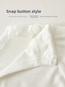 Détail des boutons-pression à l'épaule sur body bébé blanc pour un habillage facile