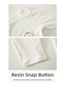 Détail d'un body bébé blanc à manches longues avec boutons-pression et coton doux