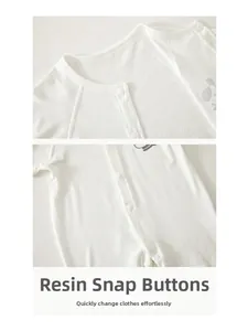 Detail der Harzdruckknöpfe und des atmungsaktiven Netzgewebes am weißen Baby-Body