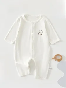 Nahaufnahme weißer Baby-Strampler mit Druckknöpfen und süßem Welpen-Print auf Stoff