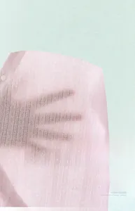 Detail of pink cotton baby bodysuit featuring breathable mesh fabric and white buttons