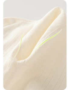 Close-up of breathable knit cotton fabric with delicate hollow pattern and resin button